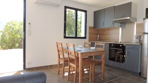 Eine moderne Küche mit grauen Schränken, einem Edelstahlkühlschrank und einem eingebauten Backofen.