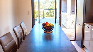 A dining area with a table, chairs, and a fruit bowl. - Casa Cavu di Santa Lucia (Zonza)