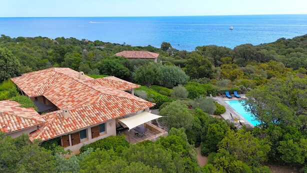A villa with a tiled roof, a swimming pool, and a view of the sea. - Villa A Pinedda Mare (Zonza)