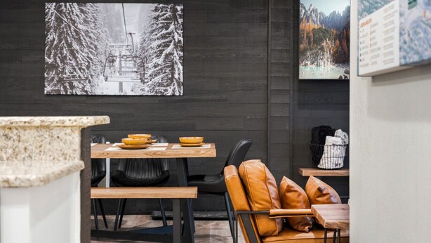 A modern dining area with a wooden table, black chairs, and a leather sofa. - NEW! Ski, Sauna, Jacuzzi, Nintendo, Game Room, Fireplace (Brian Head)