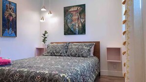 A bedroom with a bed, a painting, a plant, and pendant lights. - Charming 3-bedroom house in welcoming Torrance with AC (Torrance)