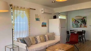 A modern living room with a sofa, coffee table, and dining area. - Charming 3-bedroom house in welcoming Torrance with AC (Torrance)