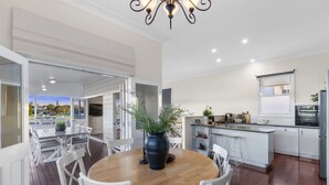 Een moderne keuken met een centraal eiland, witte kasten en uitzicht op de omgeving.