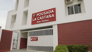 A building with a sign reading "Pousada La Castana" and a red gate. - Pousada La Castaña (Belém)