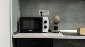 A compact kitchen with a microwave, coffee maker, and a refrigerator. - Velaris Downtown Retreat 24/7 Check-in (București)