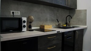 A kitchen with a microwave, a sink, and a dishwasher. - Velaris Downtown Retreat 24/7 Check-in (București)