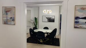 A dining area with a round table, black chairs, and a modern light fixture. - Stunning Home Downtown with free street parking! Sleeps 10 (Columbus)