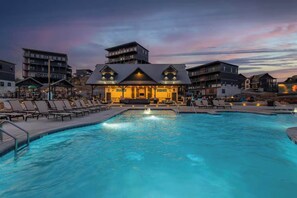 Piscina con sillones de descanso y zona de bar con un letrero que dice "DRINKS".