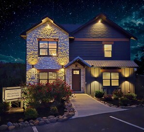 A two-story house with a stone facade and a well-lit entrance. - Heated Pool-Mtn View-Game Loft-Waterpark-Sleeps 20 (Sevierville)