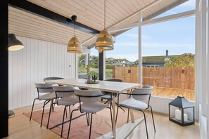 A modern dining area with a wooden table, grey chairs, and pendant lights. - Lovely bright cottage near Karrebæksminde (Karrebæksminde)