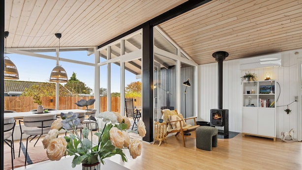 Un salon moderne avec un plancher en bois, une cheminée et un coin repas comprenant une table et des chaises.