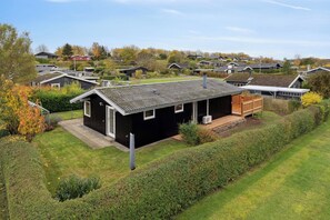 Un quartier résidentiel composé de plusieurs maisons, doté d’une pelouse bien entretenue et d’une terrasse en bois.