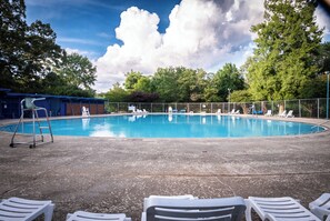 A swimming pool with lounge chairs, a ladder, and a covered area with chairs. - Private 3-Bed Lakewood Home w/Free Arcade Play- 5 Miles to Mercedes Benz Stadium (Atlanta)