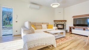 A living room with a sofa, coffee table, TV, fireplace, and a door leading to a balcony. - 1 bedroom lovely apartment in Recco (Recco)