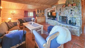 A cozy log cabin interior with a stone fireplace, wooden furniture, and a television. - 4 bedroom gorgeous home in Rjukan (Rjukan)