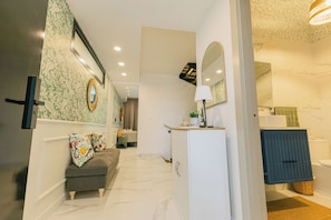 A modern bathroom with a white vanity, a mirror, and a shower area.