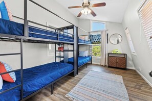 A bunk bed room with a ceiling fan, a small table with a mirror, and a window with blinds. - 3 Kings! Hot Tub/Pool-Fire Pit-GameRm GYM+ PickleB (Canyon Lake)