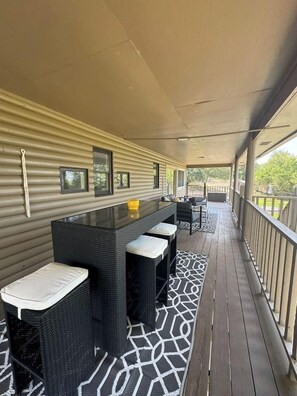A covered outdoor area with a long table and chairs, a bench, and a patterned rug. - 3 Kings! Hot Tub/Pool-Fire Pit-GameRm GYM+ PickleB (Canyon Lake)