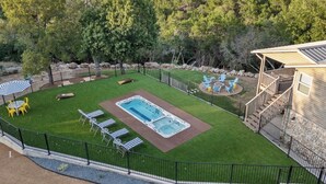 Ein Garten mit Whirlpool, Feuerstelle und Gartenmöbeln.