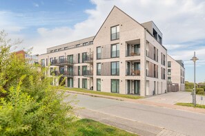 A multi-story residential building with balconies, large windows, and a flat roof. - Luxusfewo auf Nordstrand am Meer (Nordstrand)