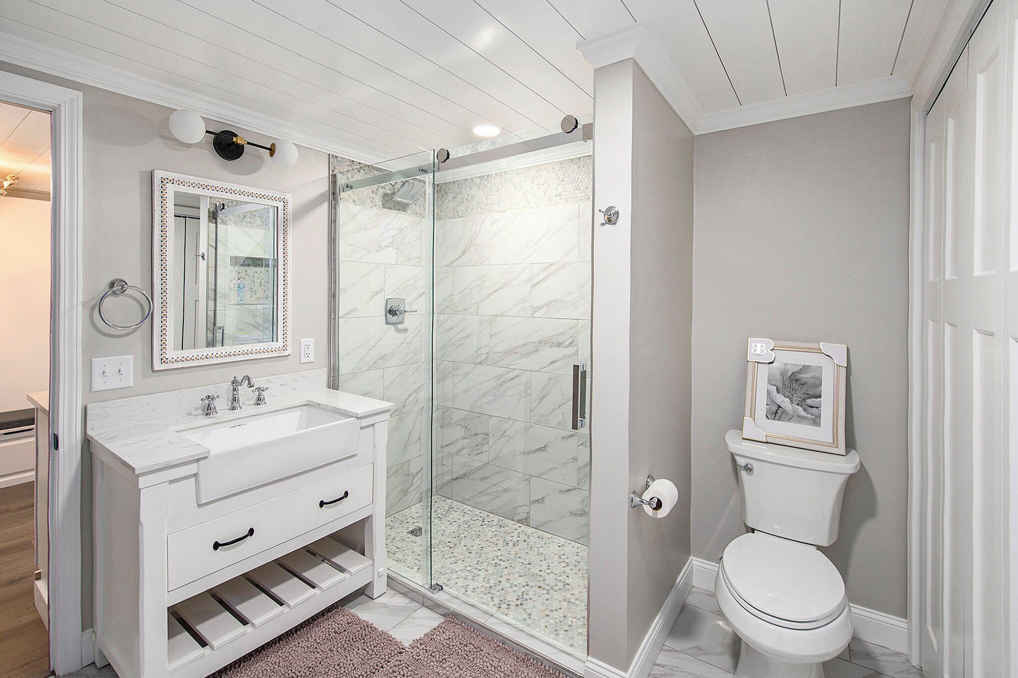 A bathroom with a white vanity, a glass shower enclosure, and a toilet.