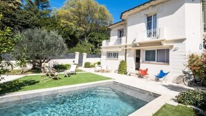 A two-story house with a swimming pool, a well-maintained lawn, and a bicycle parked outside. - Villa in Cannes With Pool and Garden (Cannes)