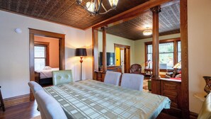 A spacious room with a large dining table, a comfortable sofa, and a television. - Updated Home near downtown Grand Haven - First Floor (Grand Haven)