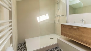 A modern bathroom with a glass shower enclosure, a wooden vanity, and a large mirror. - Lixus Suite with private terrace and kitchen (Bordeaux)