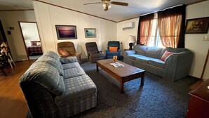 A living room with a sofa, armchairs, a coffee table, and a ceiling fan. - Lakeside Valentine (Kingsland)