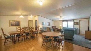 A spacious living area with a dining table, chairs, a sofa, and a TV. - Lakeside Valentine (Kingsland)