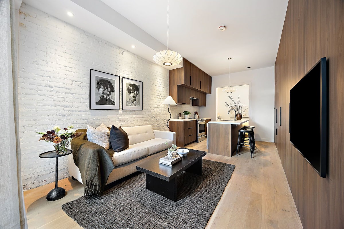 A modern living room with a sofa, coffee table, and artwork on the wall.