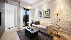 A modern living room with a sofa, a coffee table, and a floor lamp. - The Brick Hotel (Toronto)