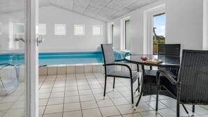 Un patio couvert avec une piscine, des sièges d’extérieur et une vue sur le paysage.