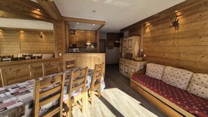 A cozy cabin interior with a dining area, a sofa, and a kitchen. - Apartment in the Val Claret Area (Tignes)