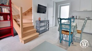 Eine moderne Wohnung mit Treppe, Essbereich und Küche.