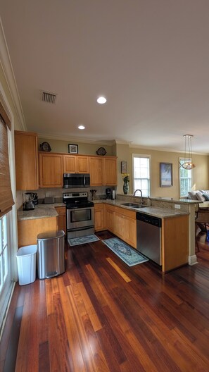 A modern kitchen with wooden cabinets, stainless steel appliances, and a large island. - Angler's Reef : Oceanside Beach, Pool, Sandbar, Kayaks & Boat Slip Available (Islamorada)