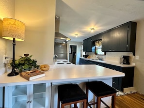 Superior huis, balkon | Privékeuken | Een magnetron, een oven, een kookplaat, kookgerei, borden en bestek