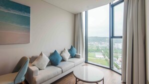 Ein modernes Wohnzimmer mit einer Couch, einem runden Couchtisch und einem großen Fenster mit Blick auf die Stadt.