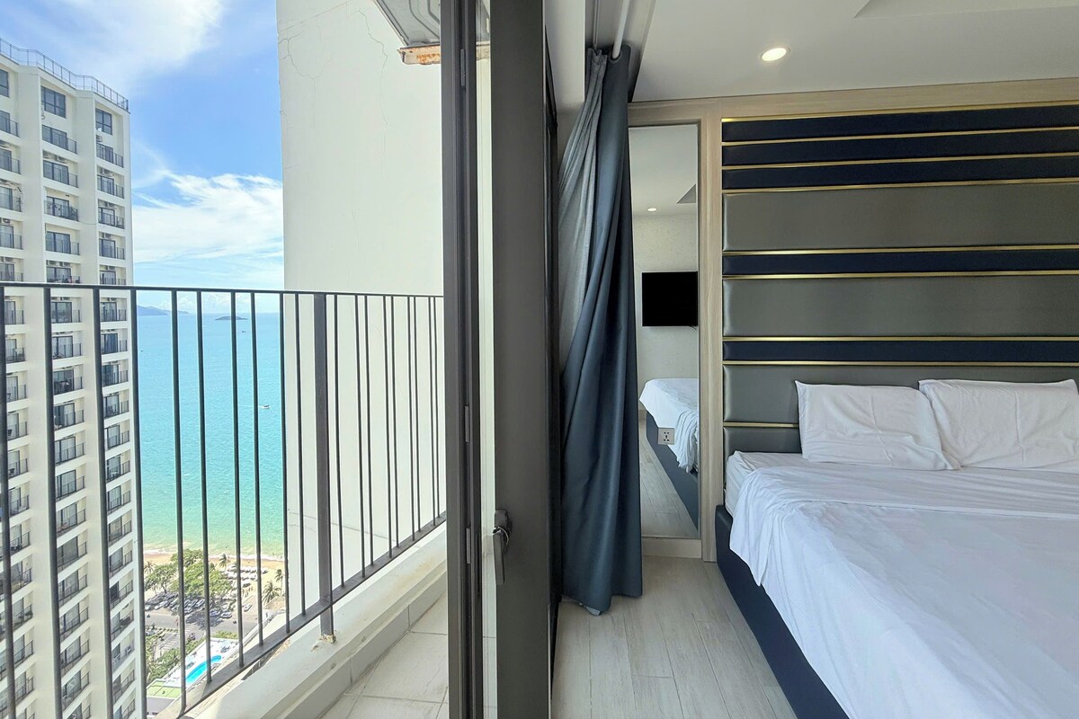 A hotel room with a balcony, a bed, and a TV.