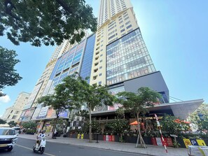 A high-rise building with multiple floors, large windows, and a variety of signage. - Apartment With Seaview (Nha Trang)