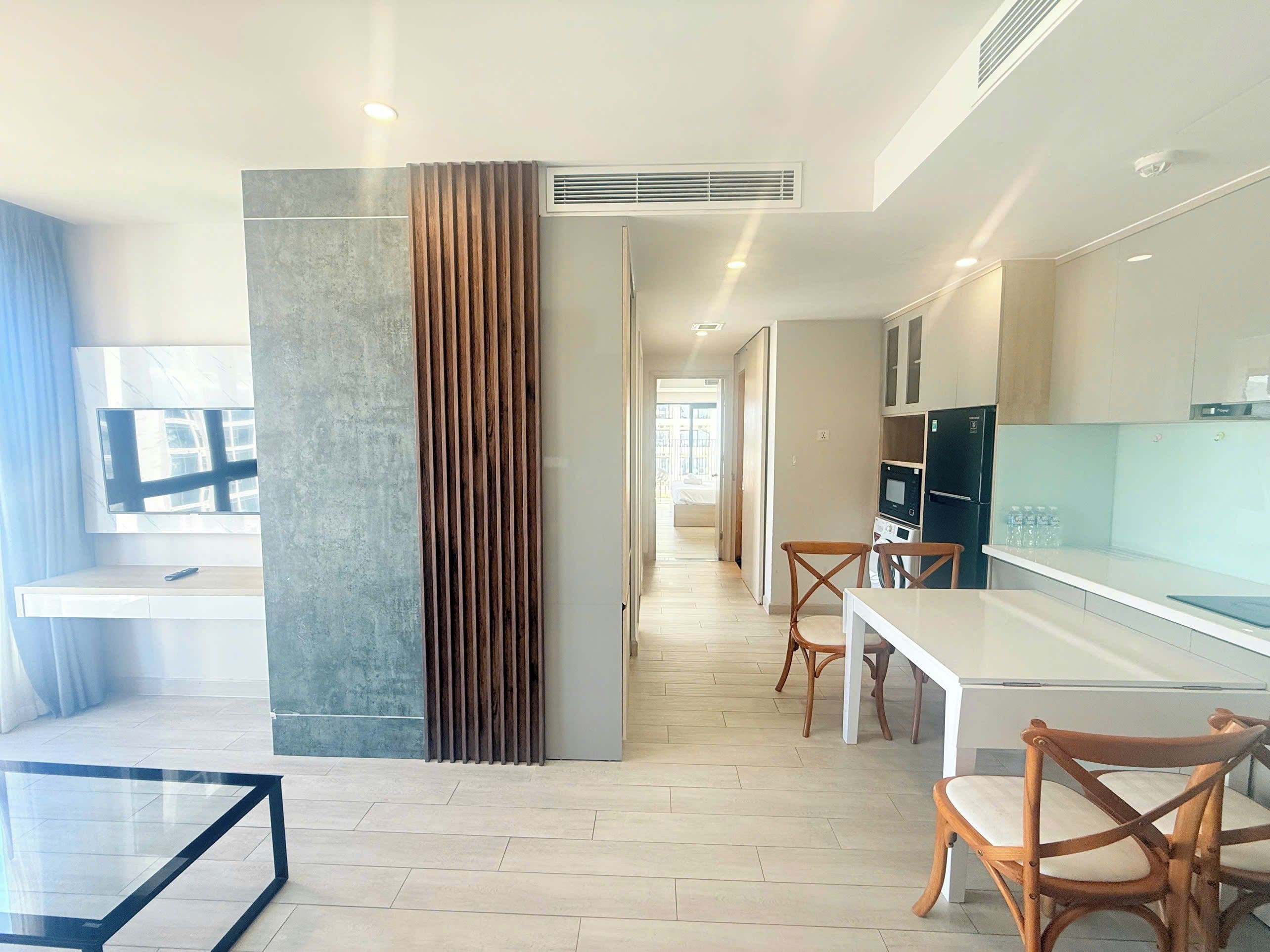 A modern kitchen with a dining area, a TV, and a view of the city.