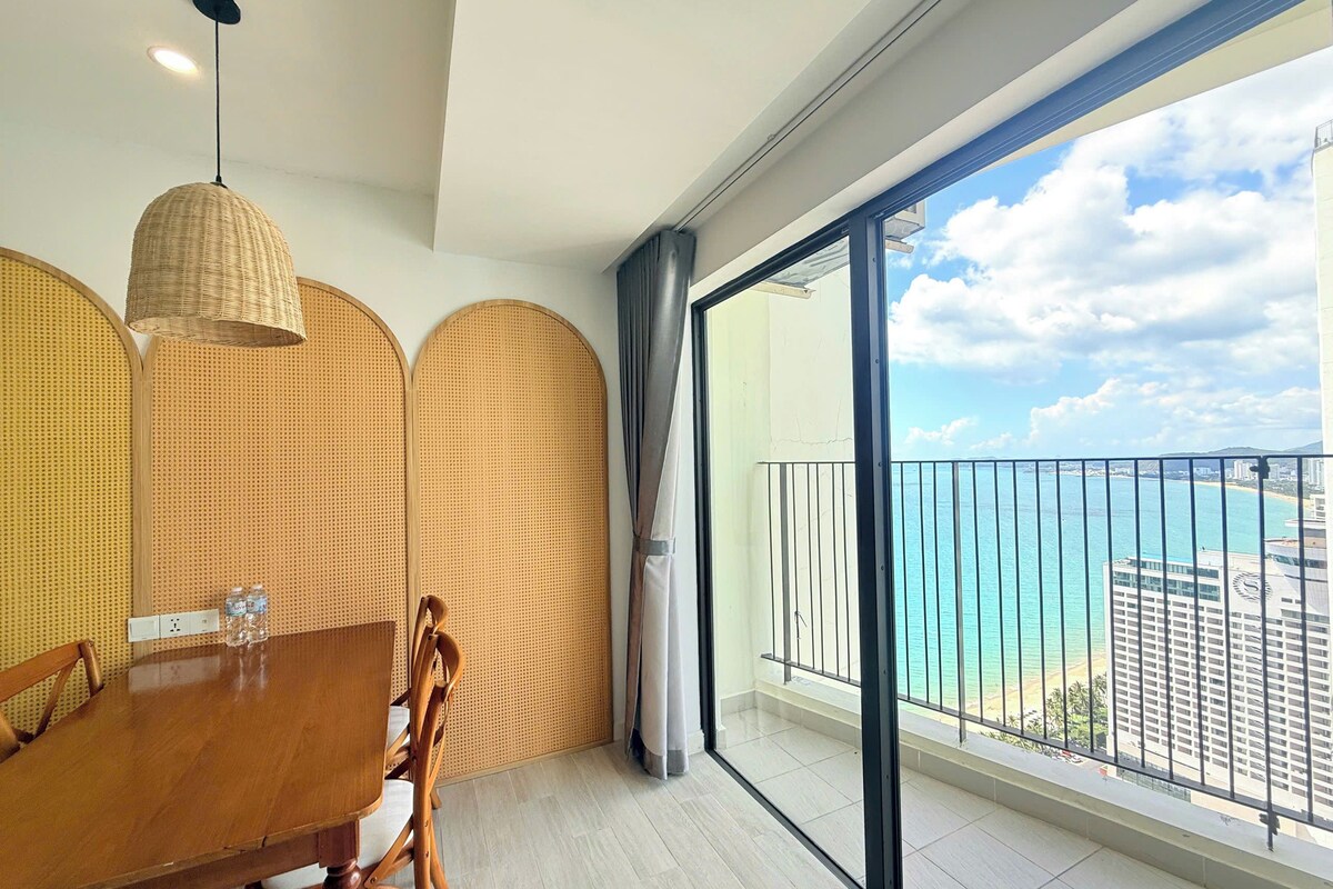 A balcony with a view of the sea and buildings.
