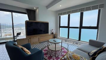 Luxury-Apartment, Balkon, Strandblick | Wohnbereich | 50-Zoll-Flachbildfernseher mit Digitalempfang