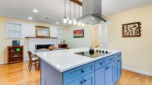 A kitchen with a central island, blue cabinets, and a white countertop. - Dew Drop Inn | 4BR Retreat | Lakeside | Hot Tub (Quinton)