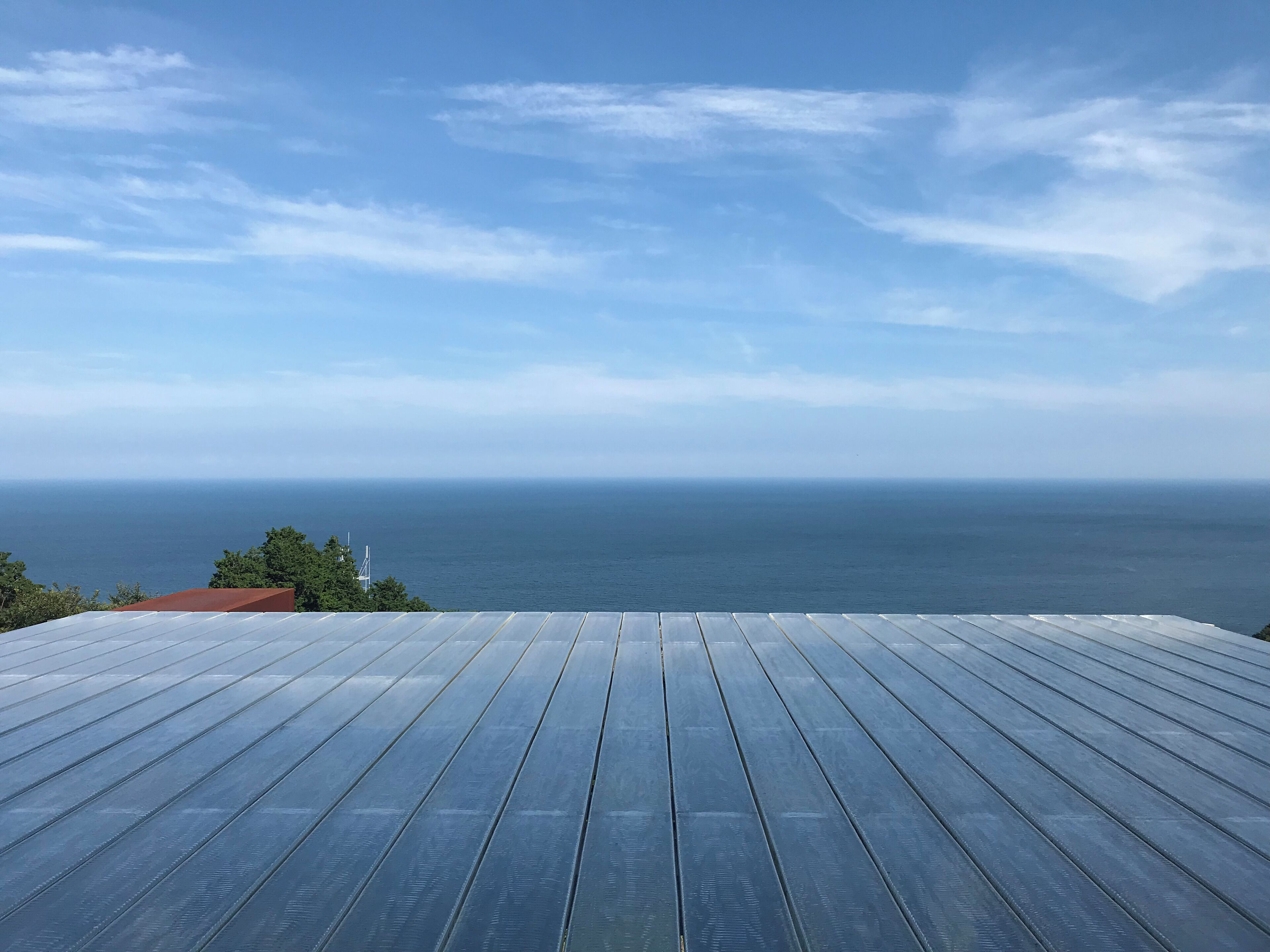Eine Holzterrasse mit Blick auf den Ozean.