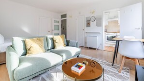 A modern living room with a sofa, coffee table, and a dining area with a chair and table. - Blueground | Lambeth, wifi, nr Kennington Park (London)