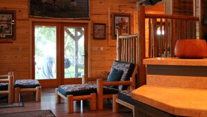 A wooden interior with a staircase, a bench, and a door leading outside. - Cozy Private Lakefront Terry Redlin-Style Cabin w/ Unique Loft (Brainerd)