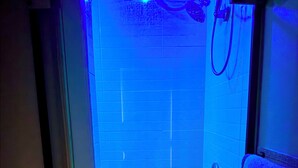 A bathroom with a glass enclosure, a shower area, and a towel rack.