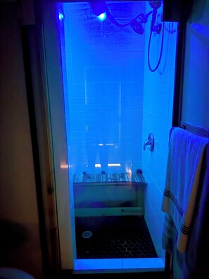 Un baño con cabina de vidrio, zona de ducha y un perchero para toallas.