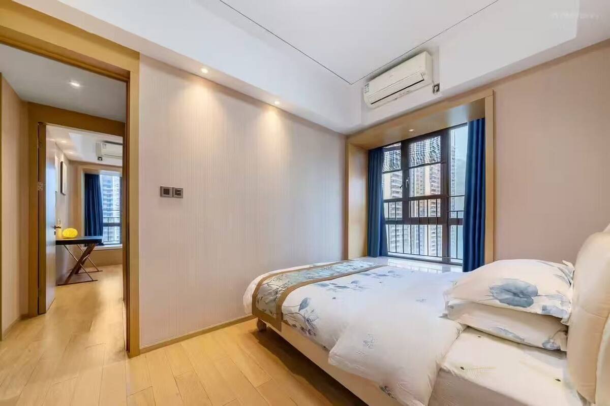 Une chambre à coucher avec un lit, une fenêtre et un appareil de climatisation.